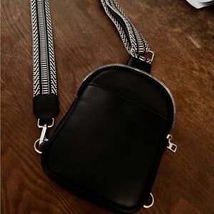 Black Vegan leather cross body bag. It has a few compartments can hold phone